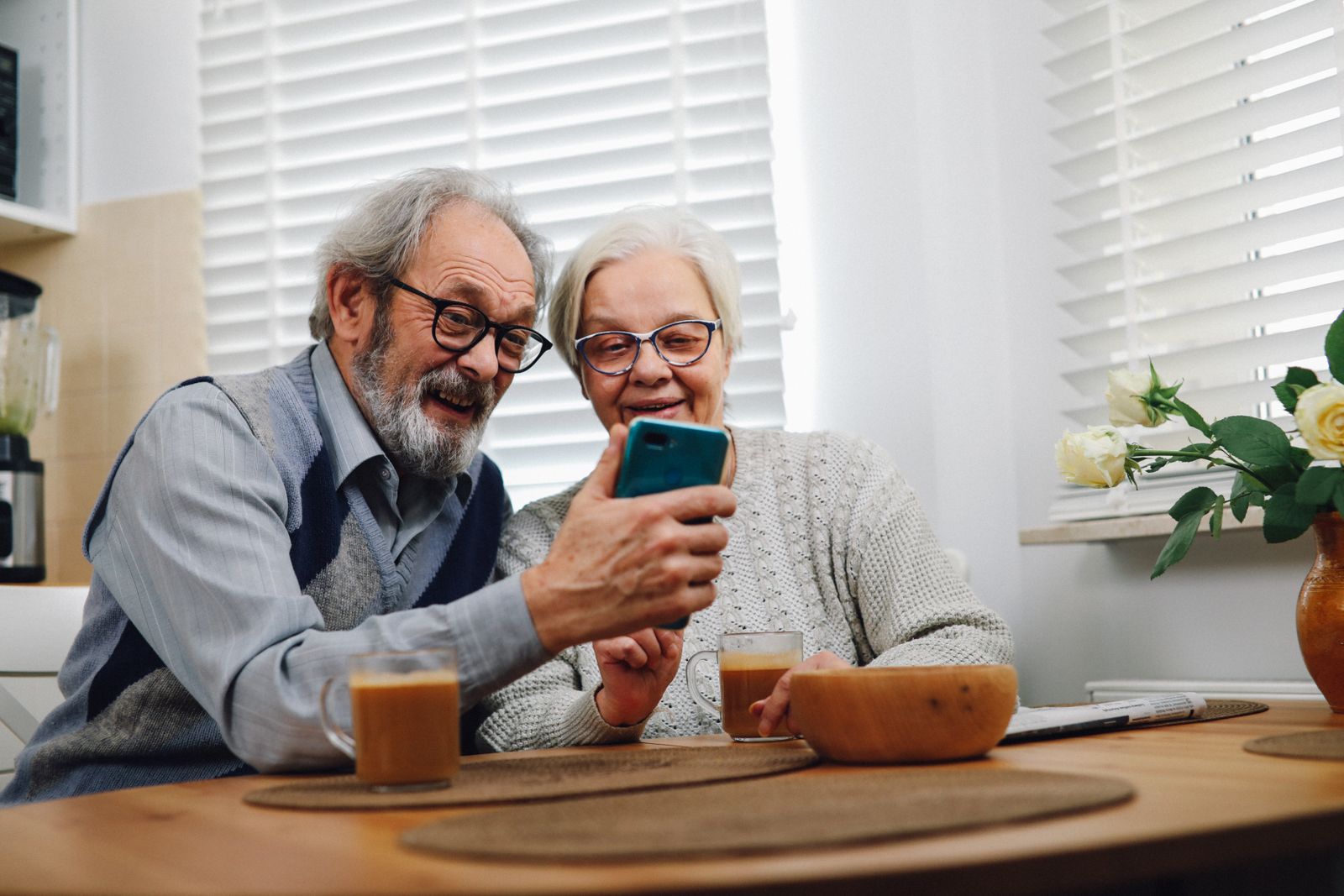 Älteres Ehepaar schaut gemeinsam auf ein Smartphone